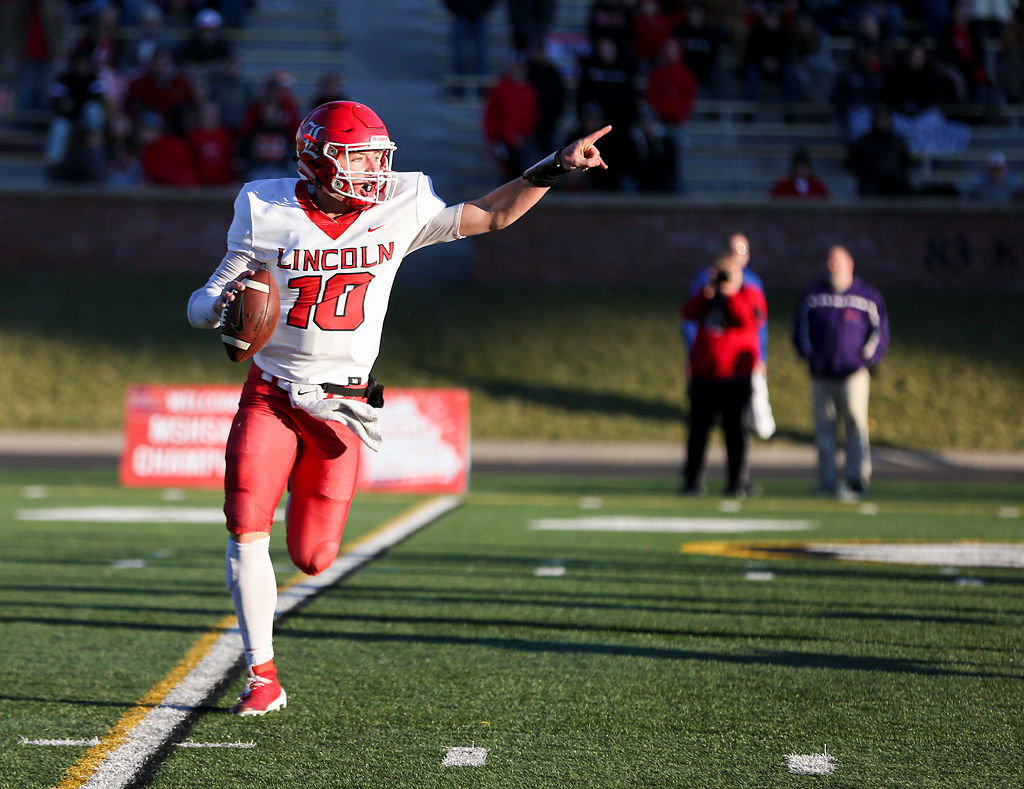 incoln quarterback Jackson Beaman motions to a teammate